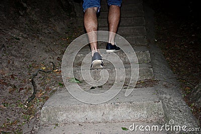 A young man walks in the woods outdoors the stairs Stock Photo