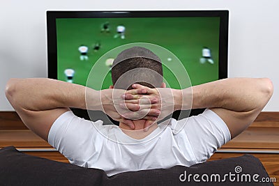 Young man watching football on tv Stock Photo