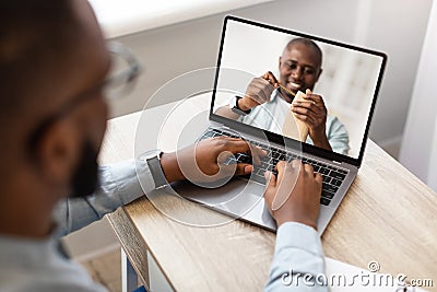 Young man watching online DIY class, participating in woodworking workshop, using laptop at home Stock Photo