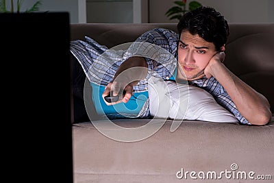 The young man watching tv late at night Stock Photo