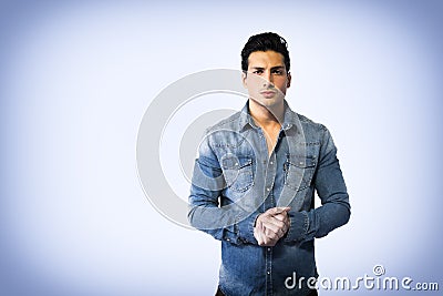Young man wearing denim shirt, hands joined together Stock Photo