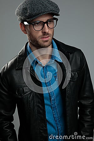 Young man wearing grey flat cap looks down to side Stock Photo