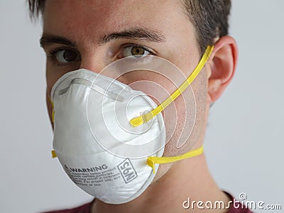 Young Man Wearing an N95 Respirator Dust Mask Up Close Stock Photo
