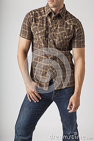 Young man wearing plaid western wear shirt and denim jeans. Men`s trendy casual clothing fashions styles. Stock Photo