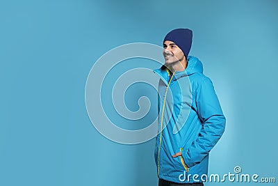 Young man wearing warm clothes on color background, space for text. Ready for winter Stock Photo