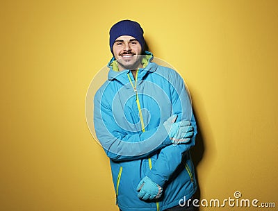 Young man wearing warm clothes on color background, space for text. Ready for winter Stock Photo