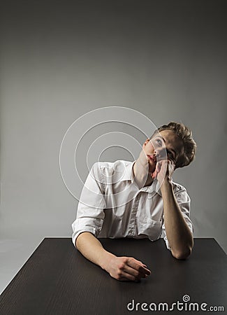 Young man in white is full of doubts and hesitation. Dreamer Stock Photo