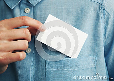 Young man who takes out blank business card from the pocket of his shirt Stock Photo
