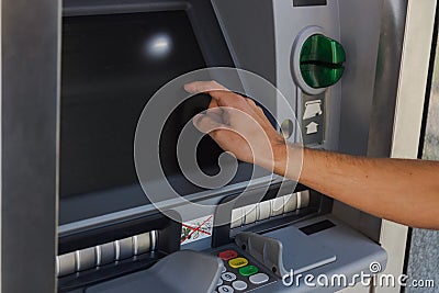 Young man withdrawing cash from a cash machine Stock Photo