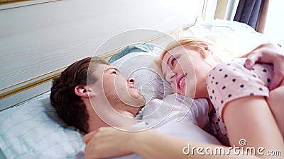 Young Man And Woman In Bed In Night Wear Smiling At Each Other In 