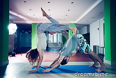 Young man and woman doing acro yoga indoor Stock Photo