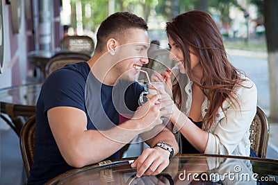 Young man and woman sharing drink in a cafe Stock Photo