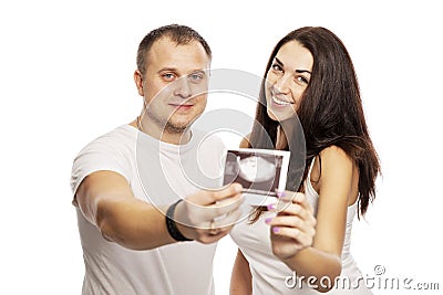 Young man and woman show the result of ultrasound. Early gestational age. Love and happiness waiting Stock Photo