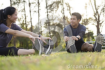 Young man and woman stretching in the park Stock Photo