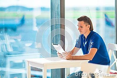 Young man working with laptop at airport cafe Stock Photo