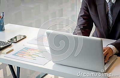 Young man working with laptop on his desk in office, man& x27;s hands Stock Photo