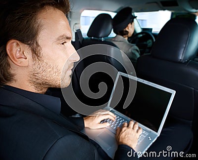 Young man working on laptop in limousine Stock Photo