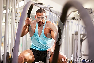 Young man working out with battle ropes at a gym Stock Photo