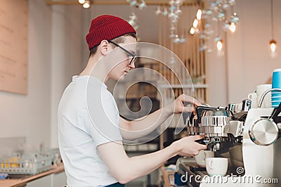 Barista stands behind the coffee machine and makes coffee Stock Photo