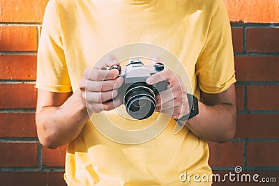 young man holds in his hands an analogical camera Stock Photo