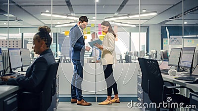 Young Manager Creating Project Plan with Experienced Colleague on Office Wall with Paper Notes Stock Photo