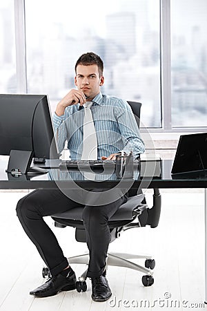 Young manager sitting in modern office Stock Photo