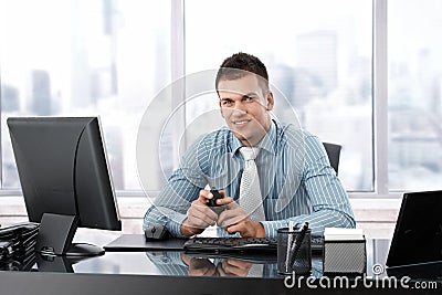 Young manager smiling at desk Stock Photo