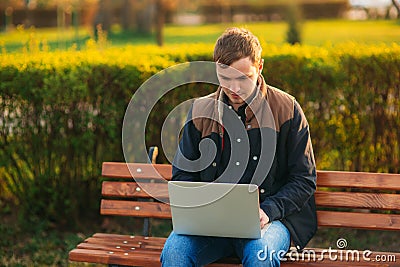 The young manager working on a laptop in the park. Lunch Break. Stock Photo