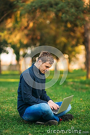 The young manager working on a laptop in the park. Lunch Break. Stock Photo