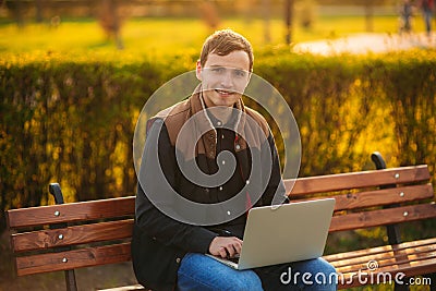 The young manager working on a laptop in the park. Lunch Break. Stock Photo