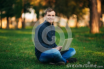 The young manager working on a laptop in the park. Lunch Break. Stock Photo