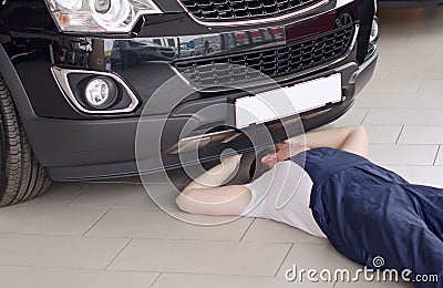 Young mechanic under car. Stock Photo