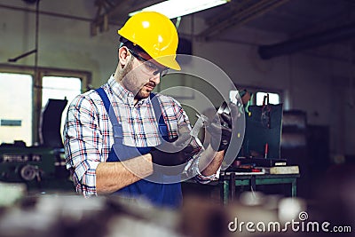 Mechanical technician measuring with caliper in workshop Stock Photo