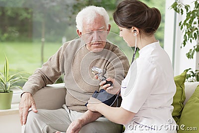 Young medic taking blood pressure Stock Photo