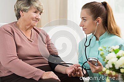 Young medic taking blood pressure Stock Photo