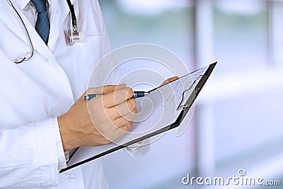 Young medical doctor with a stethoscope around his neck holding a black folder Stock Photo