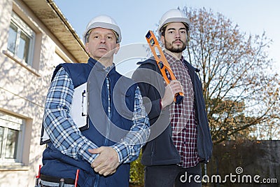 Young man carrying builders level in construction site Stock Photo