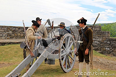 Young men dressed in soldier`s uniforms, demonstrating firing a canon, Fort Ticonderoga, New York, 2016 Editorial Stock Photo