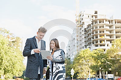 Young man and girl on the street looking at the tablet. Stock Photo