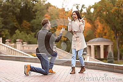 Young man proposing to his beloved in autumn park Stock Photo