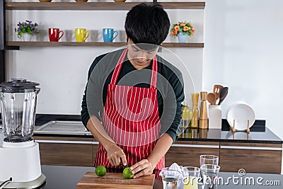 Young men squeezing lemonade in the kitchen Stock Photo