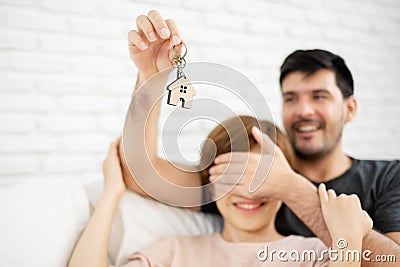 Man surprising woman with a key of their new house. Stock Photo