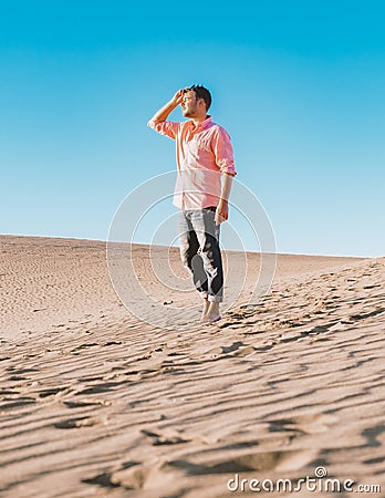 Young men walking at the beach of Maspalomas Gran Canaria Spain, men at the sand dunes desert Stock Photo