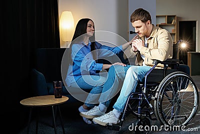 Young man in a wheelchair. Girlfriend comforting her sad boyfriend Stock Photo