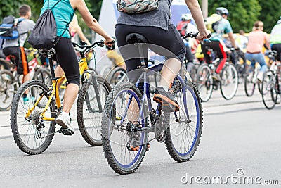 Young men and women cycling on city street Stock Photo