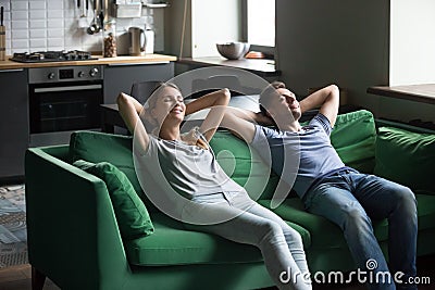 Happy couple leaning on sofa together, stress free weekend conce Stock Photo