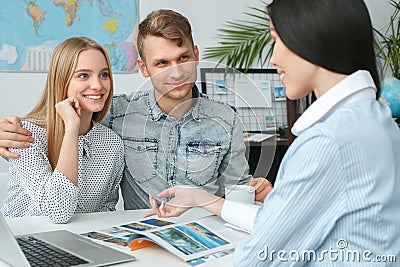 Young couple in a tour agency communication with a travel agent travelling concept tour destination Stock Photo