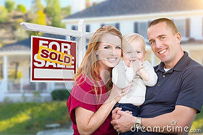 Young Military Family in Front of Sold Sign and House Stock Photo