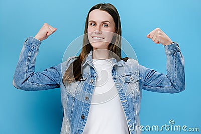 Young millennial female showing biceps and looking confident, feeling power strength to fight for female rights Stock Photo
