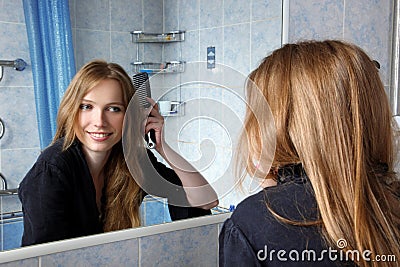 Young of a mirror correcting hairs Stock Photo